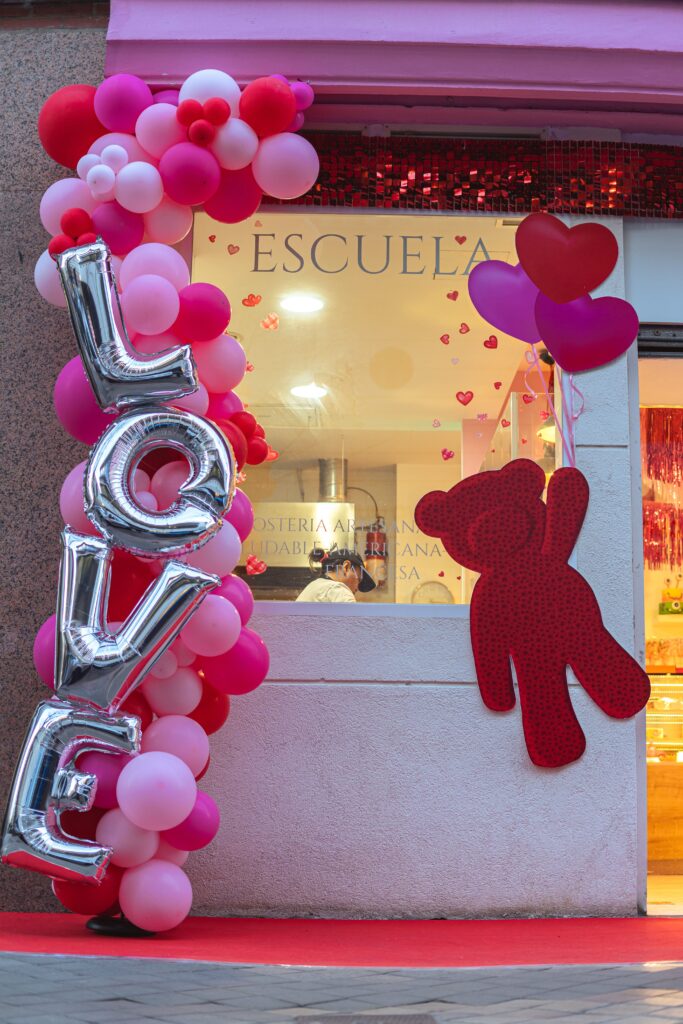 decoración san valentin con arco de globos o guirnalda de globos rosas y rojos y oso rojo decorativo con corazones