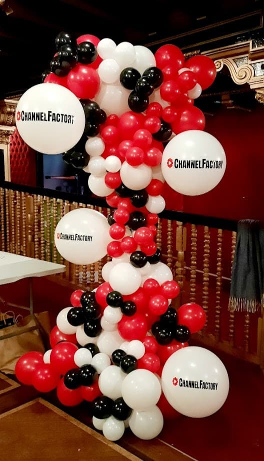 columna de globos personalizados con maxi globos y logo personalizado en colores rojo, negro y blanco
