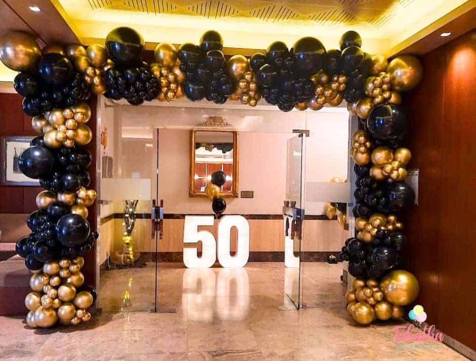 decoración de 50 cumpleaños en Madrid con globos dorados y negros y números rellenos de luces 50