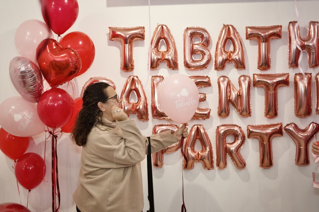 mujer explotando un globo para el sorteo de galentine's party en tabatha decora tu fiesta