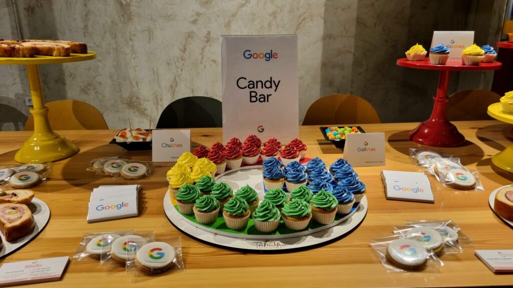 decoracion de mesa de dulces con la g de google mini cupcañes rojos amarillos verdes y azules con los colores corporativos de google en un candy bar